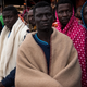 Refugees and migrants wait on deck of the Spanish NGO Proactiva Open Arms rescue vessel Golfo Azzurro to disembark after being rescued off the Libyan coast north of Sabratha, Libya, on Feb. 19, 2017. (David Ramos/Getty Images)